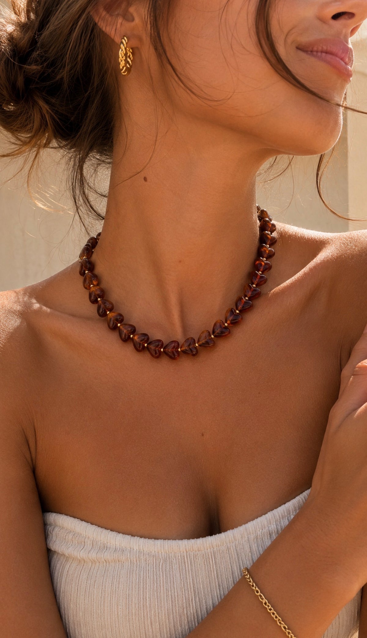 Collier Ama bordeaux composé de perles en forme de cœur, porté par une femme avec un bustier blanc. Bijou fantaisie coloré LAU.THENTIK.
