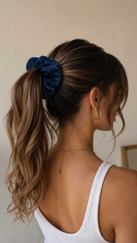 Chouchou bleu à paillettes porté dans une queue-de-cheval sur cheveux longs