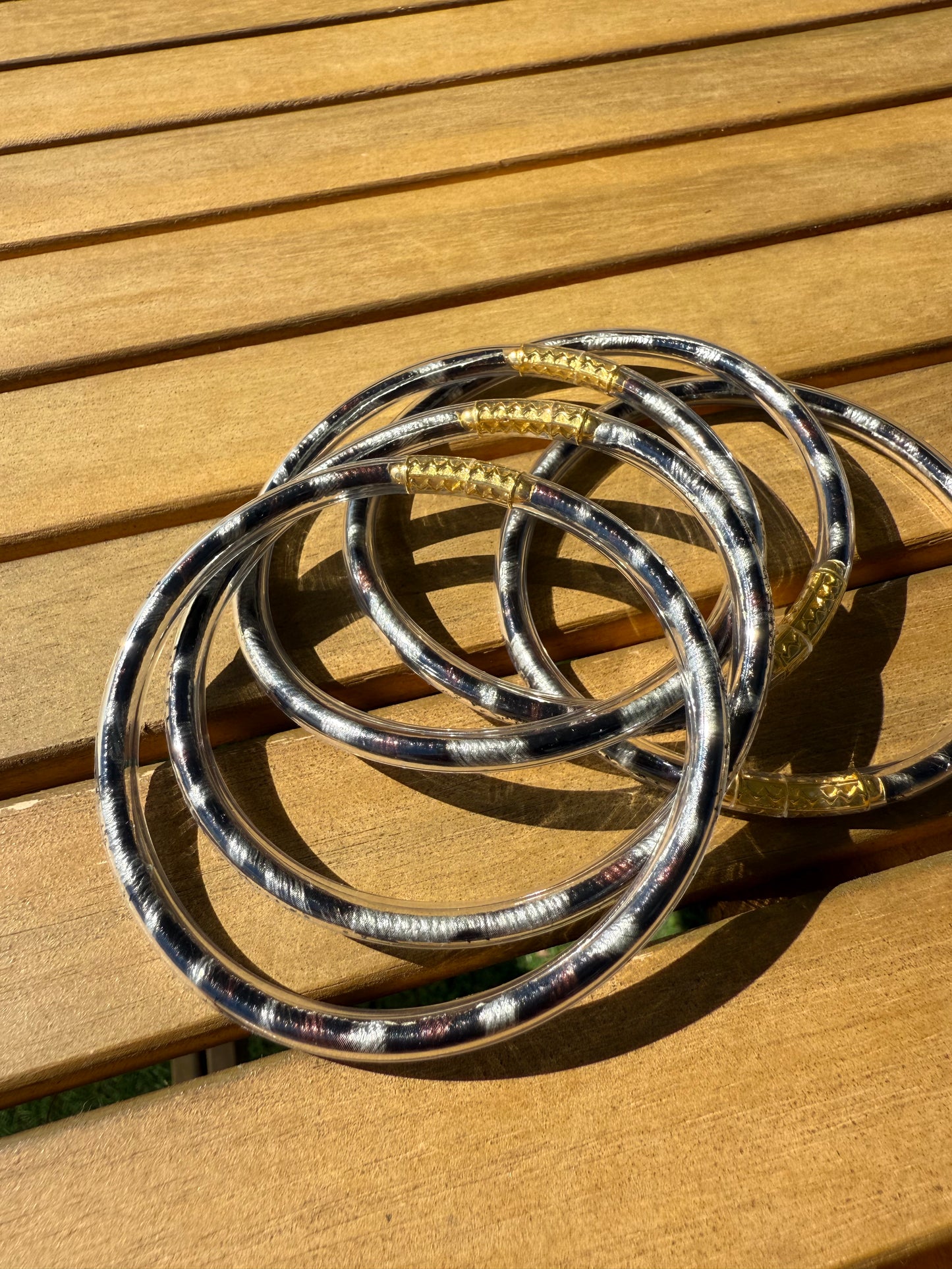 Bracelets joncs Anae à imprimé léopard présentés ensemble sur une surface en bois