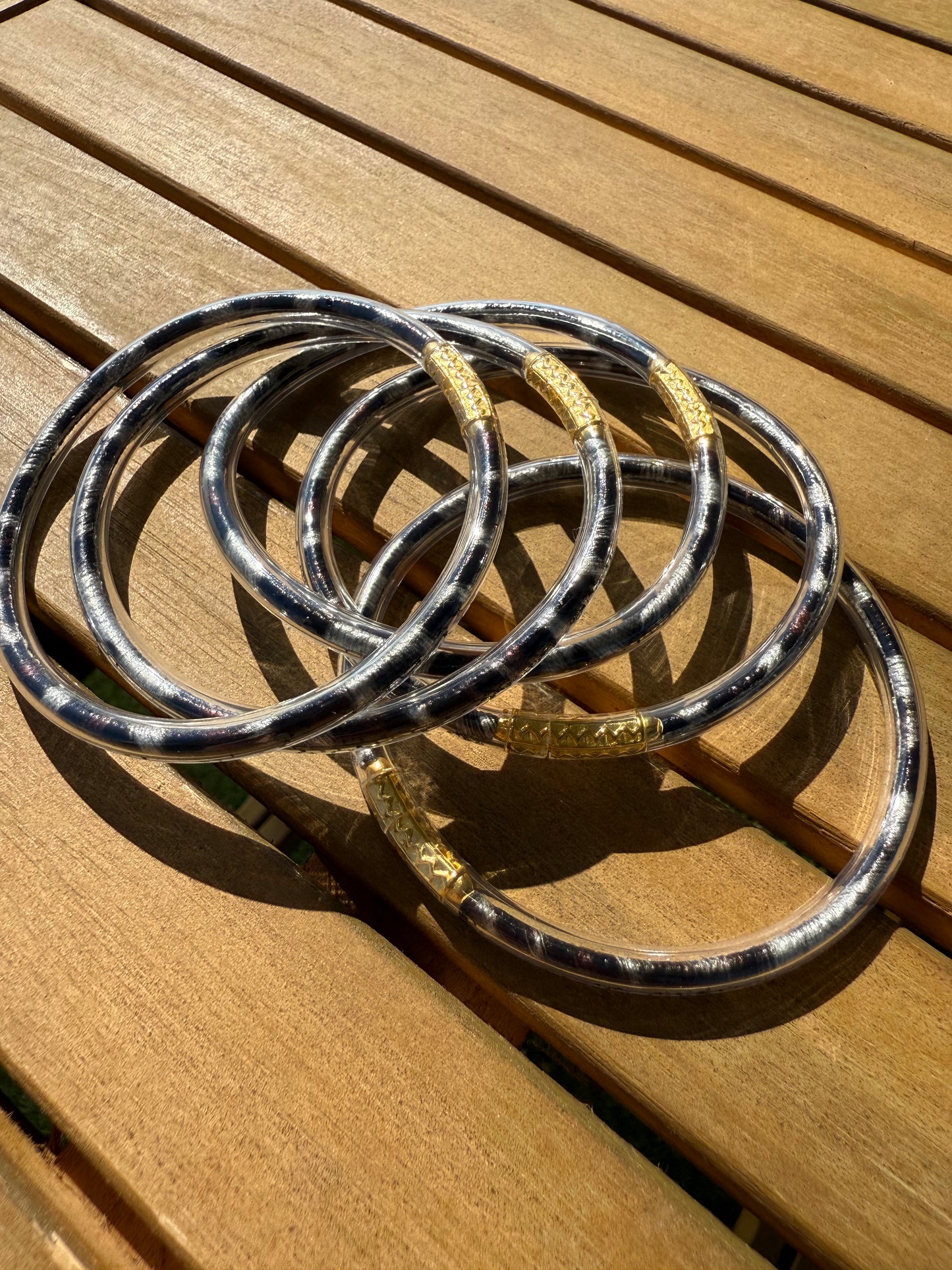 Bracelets joncs Anae à imprimé léopard présentés ensemble sur une surface en bois