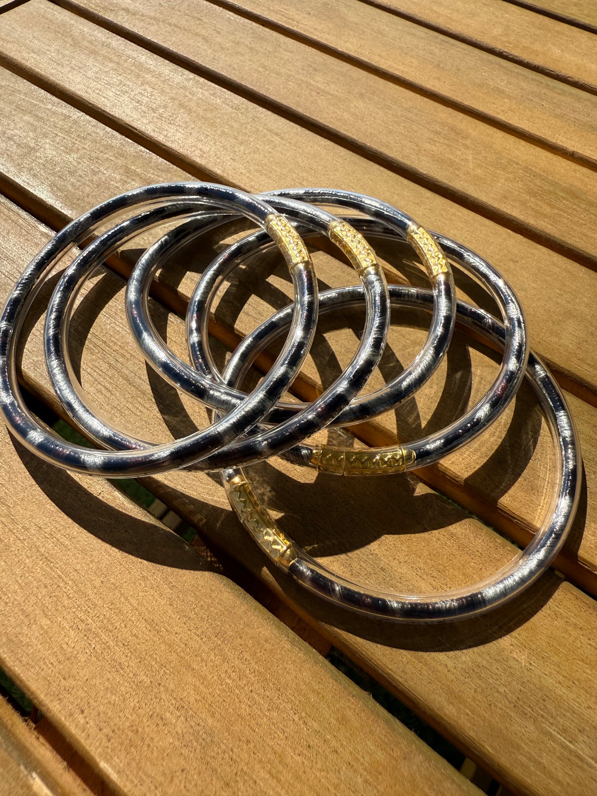 Bracelets joncs Anae à imprimé léopard présentés ensemble sur une surface en bois