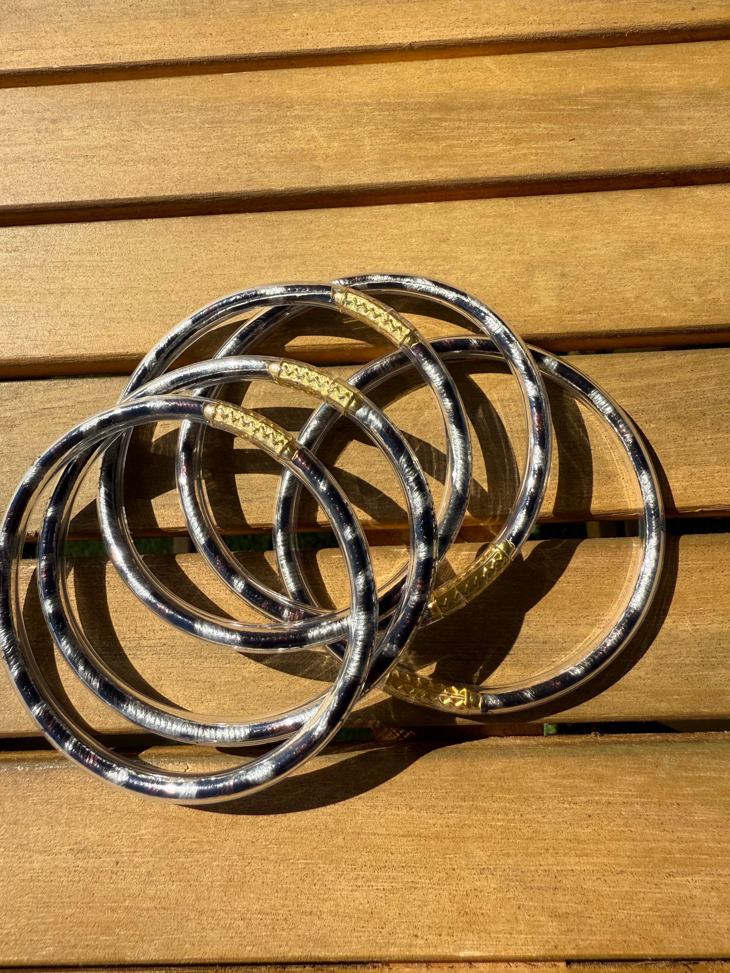 Bracelets joncs Anae à imprimé léopard présentés ensemble sur une surface en bois