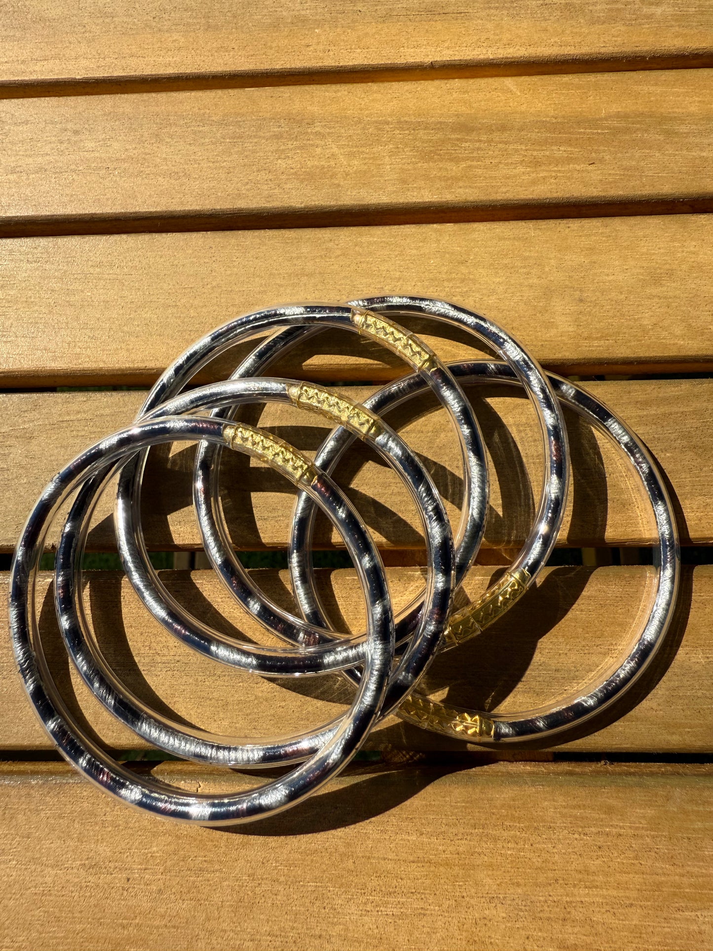 Bracelets joncs Anae à imprimé léopard présentés ensemble sur une surface en bois