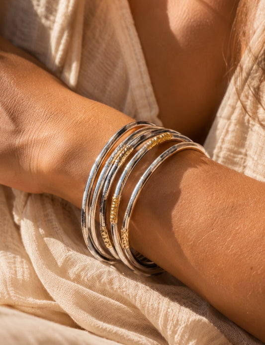 Plusieurs bracelets joncs Anae à motif léopard portés en accumulation au poignet d'une femme